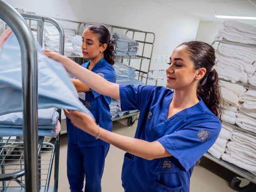 To jenter som rydder på lager på sykehjem