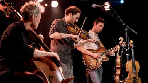 Tre mannlige musikere på en scene