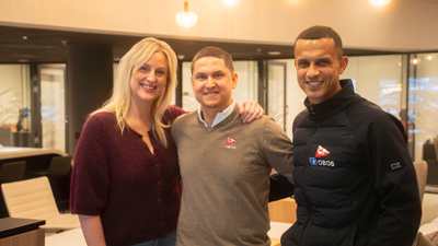 Tre blide personer smiler mot kamera. 