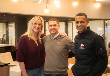 Tre blide personer smiler mot kamera. 